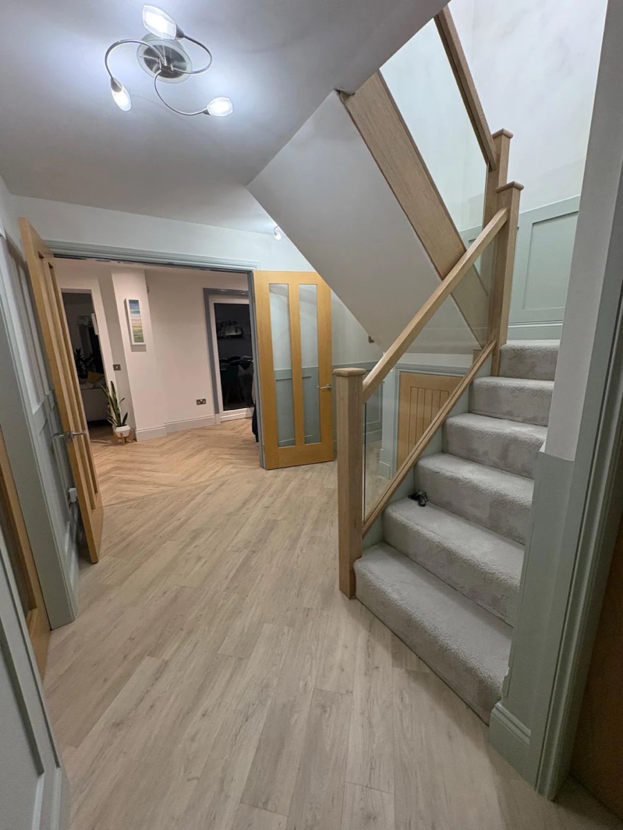 A recent A & R Flooring job — herringbone LVT hallway with new carpeted staircase